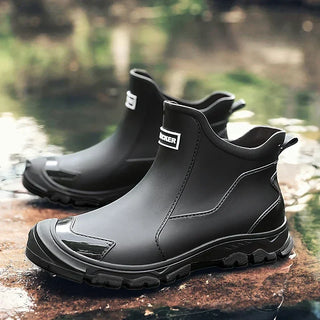 Bottines à enfiler noires à bout fermé, semelle crantée et empiècements latéraux.
