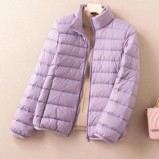 Doudoune matelassée violet clair à fermeture zippée et col montant, tenue ample.