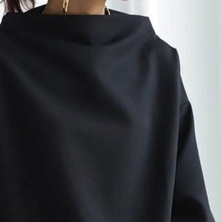Pull femme noir à col montant, vue rapprochée sur la encolure et l’épaule.