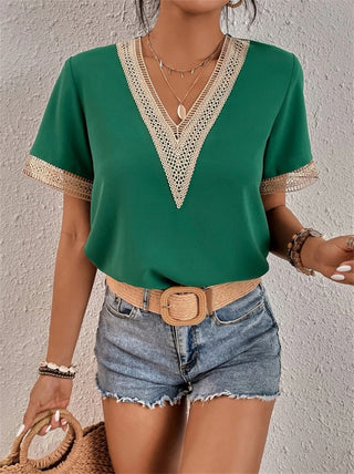 Blouse brodée à col en V, manches courtes, vert avec bordure beige.