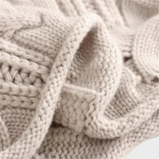Pull en cachemire beige : gros plan des torsades en relief au buste