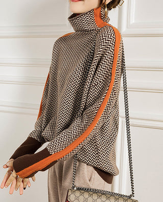 Blouse col montant motif chevrons noir et blanc, passepoil orange, bas et poignets marron.