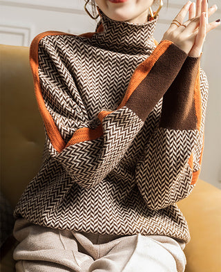Blouse motif chevrons noir et blanc, col montant, bordures orange et marron, coupe ample.