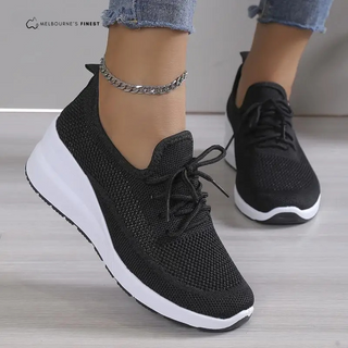 Baskets orthopédiques femme noires en maille, lacets, semelle blanche épaisse.
