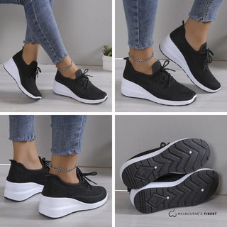 Baskets orthopédiques femme noires, vue de côté, lacets et semelle blanche.