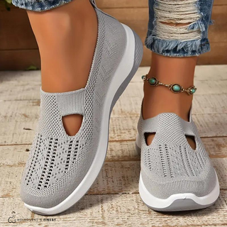 Chaussures orthopédiques grises en maille respirante, empeigne ajourée et semelle blanche.