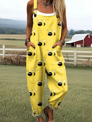 Combinaison en coton jaune à bretelles, motifs abeilles noirs et souriants.