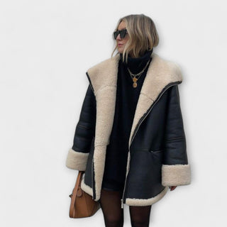 Veste en cuir noire avec doublure en peau retournée beige, col et manches