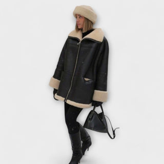 Veste en cuir noire à col en peau retournée beige, poches zippées
