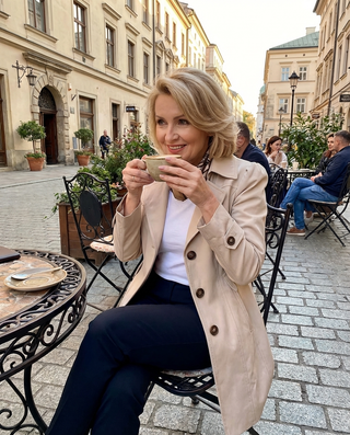 Trench beige clair sur modèle, col en pointe, patte boutonnée et manches longues.