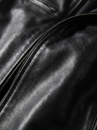 Veste en cuir noire : gros zip et surpiqûres dorées sur le devant.