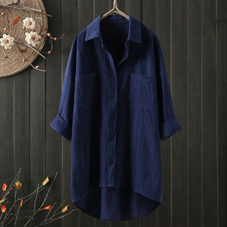 Chemise longue bleu marine à coupe ample, col chemise, boutons, poches poitrine.