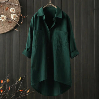 Chemise longue verte foncée à coupe ample, col chemise, boutons, poches poitrine.