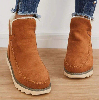 Bottes d’hiver pour femme marron à plateforme, coutures visibles et semelle à relief.