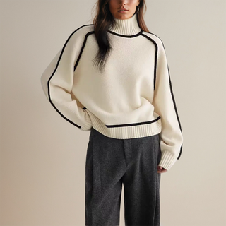 Pull col roulé beige clair en maille, poignets et bas côtelés avec liseré noir.