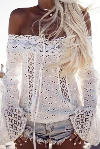 Blouse en dentelle blanche épaules dénudées, manches longues évasées, laçage devant