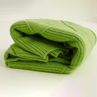 Piles de pulls verts en maille côtelée, pliées