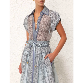 Ensemble blouse et jupe imprimées bleu, col montant et ceinture nouée à motifs.