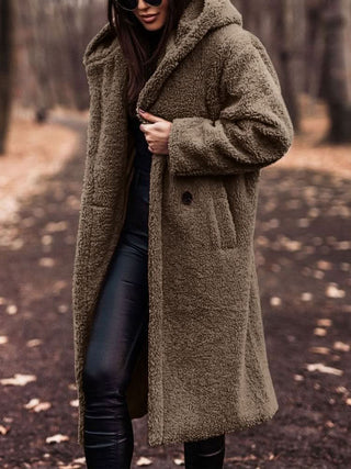 Manteau teddy beige à col châle, boutonné, tissu pelucheux, manches longues.
