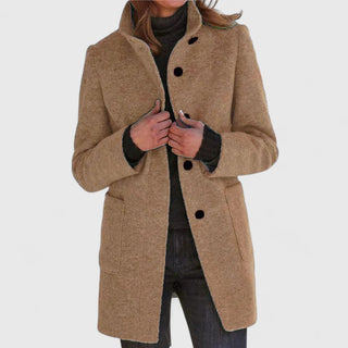Manteau classique en laine beige, fermeture boutonnée, col ouvert, poches plaquées.