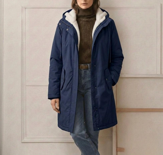 Parka longue marine imperméable, doublure en polaire, capuche et poches latérales zippées.