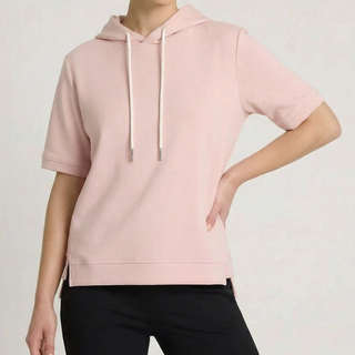 Hoodie à manches courtes rose pâle, capuche et cordons blancs, poche kangourou.