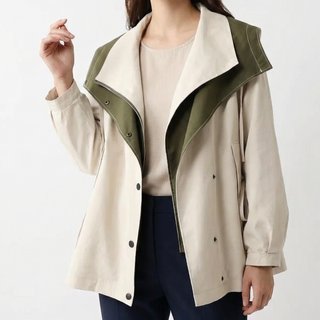 Veste légère à capuche bicolore vert olive et crème, col à revers, boutons pression.