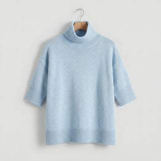 Pull oversize en maille bleu clair, col cheminée côtelé, porté sur cintre, manches courtes.