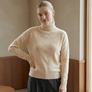 Pull col roulé beige avec losanges en relief sur le devant, manches longues
