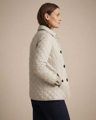 Veste boutonnée matelassée beige clair à col montant, manches longues, boutons visibles