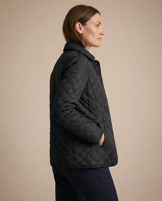 Veste boutonnée matelassée noire vue de profil, col montant, surpiqûres chevron