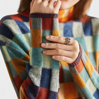 Pull en laine à carreaux multicolores, emmanchures et manchettes côtelées visibles