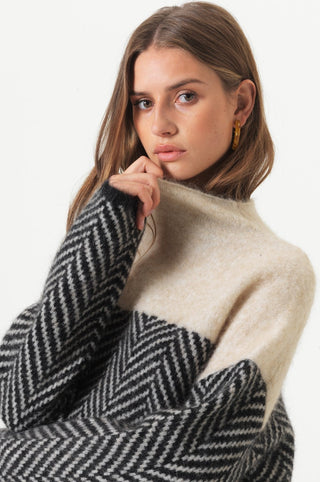 Blouse en maille à col montant beige et noir, détail motif chevrons
