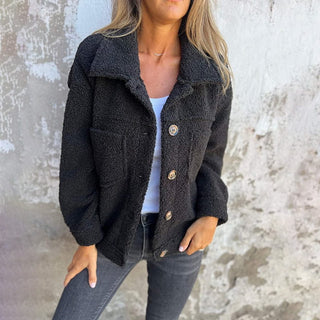 Manteau automnal bouclé noir, col à revers, boutons ronds, poches poitrine visibles