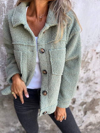 Manteau automnal bouclé vert d’eau, col ouvert, boutonnage et poches visibles