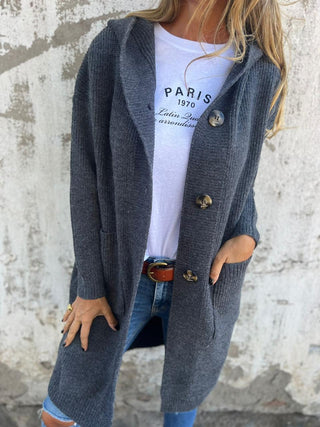 Manteau long en maille bleu-gris foncé, boutons dorés, poches et col châle.
