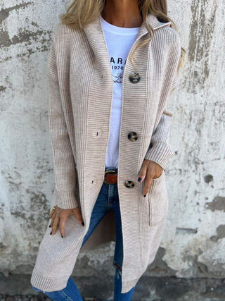 Manteau long en maille beige, boutons dorés, poches et col châle.