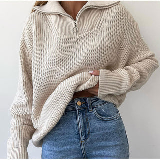 Pull en tricot beige clair, col montant zippé, maille texturée et poignets côtelés.