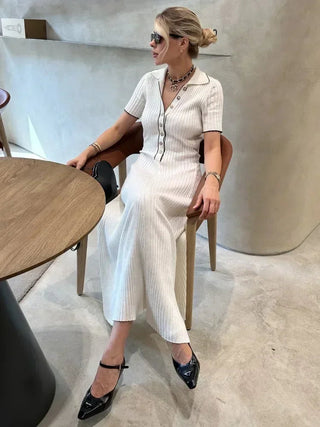 Robe en maille blanche, col V boutonné et fente, manches courtes, silhouette ajustée.