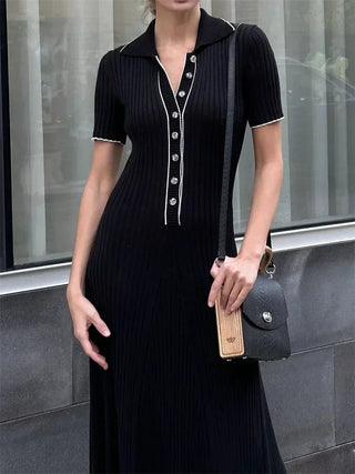 Robe noire en maille côtelée, col V à patte boutonnée avec liseré, manches courtes.