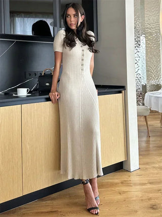 Robe longue beige en maille côtelée, col V boutonné, manches courtes, fente à l’ourlet.