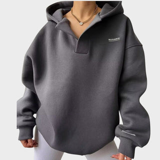 Sweat à capuche gris chic, poche kangourou, demi-col, manches longues, poignets côtelés.