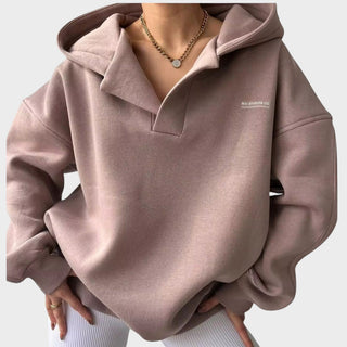 Sweat à capuche rose poudré chic, demi-col à zip, poche kangourou, manches longues.