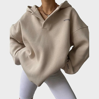 Sweat à capuche beige chic avec poche kangourou, demi-col zippé, manches longues.