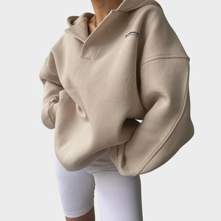 Sweat à capuche beige chic, demi-col à encolure, manches longues et poignets côtelés.