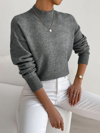 Pull en maille à col rond gris foncé, manches longues, poignets côtelés.