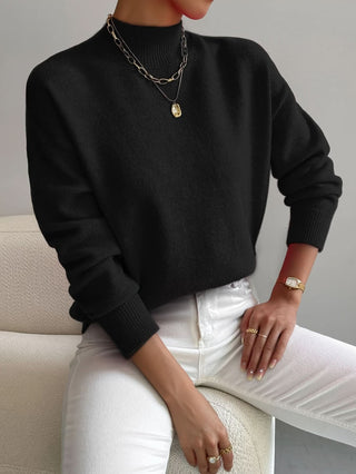 Pull en maille à col rond noir, manches longues et poignets côtelés.