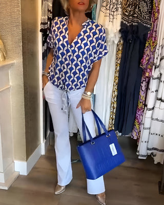Blouse décontractée Luna à encolure V, manches courtes, motif bleu et blanc, effet noué à la taille.