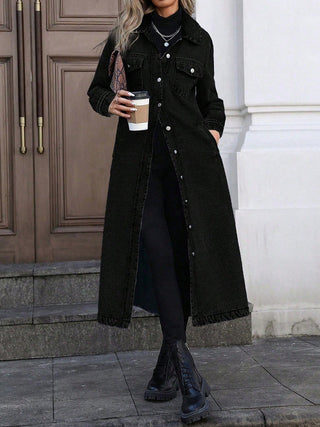 Veste longue en jean noire, fermeture à boutons, poches poitrine, col chemise, ourlet droit.