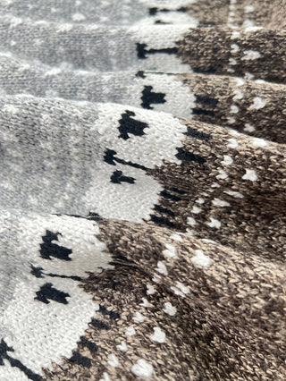 Détail du jacquard mouton sur pull en tricot épais gris et blanc, motifs contrastés